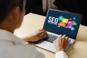 Person working on a laptop with SEO graphics for website optimization and Google rankings_png